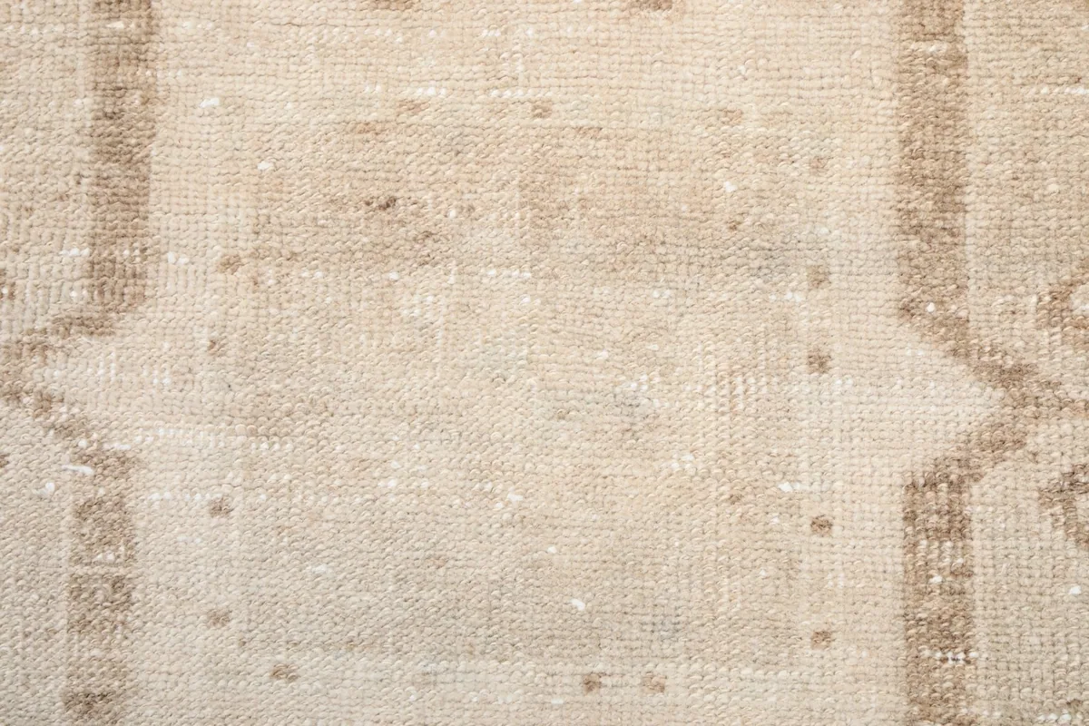Close-up of the low wool pile texture and subtle color variations across the rug surface