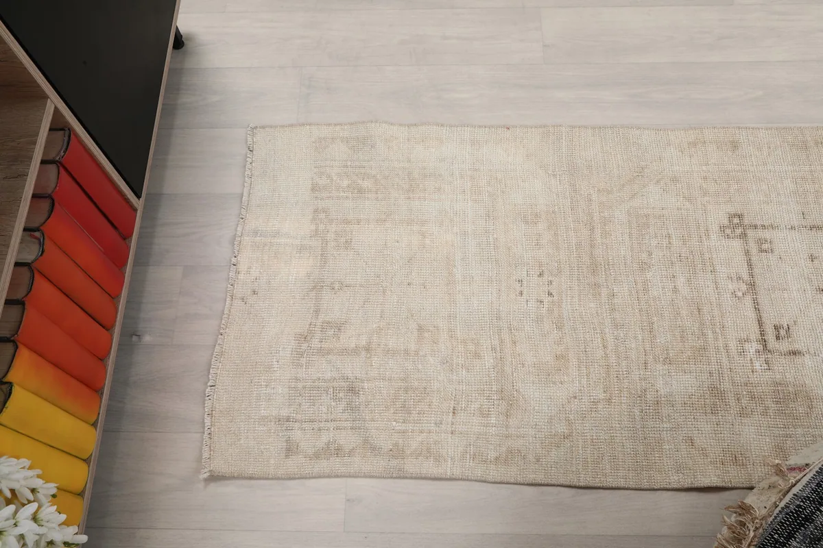 Angle view of the runner rug's end section, revealing its natural patina and subtle color variations.