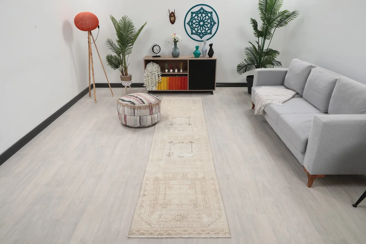 Vintage beige runner rug displayed in a modern living room setting with light flooring.