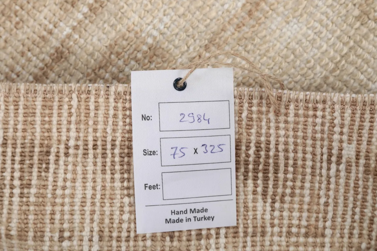 Close-up of the product tag attached to the back of the rug, showing size and origin details.