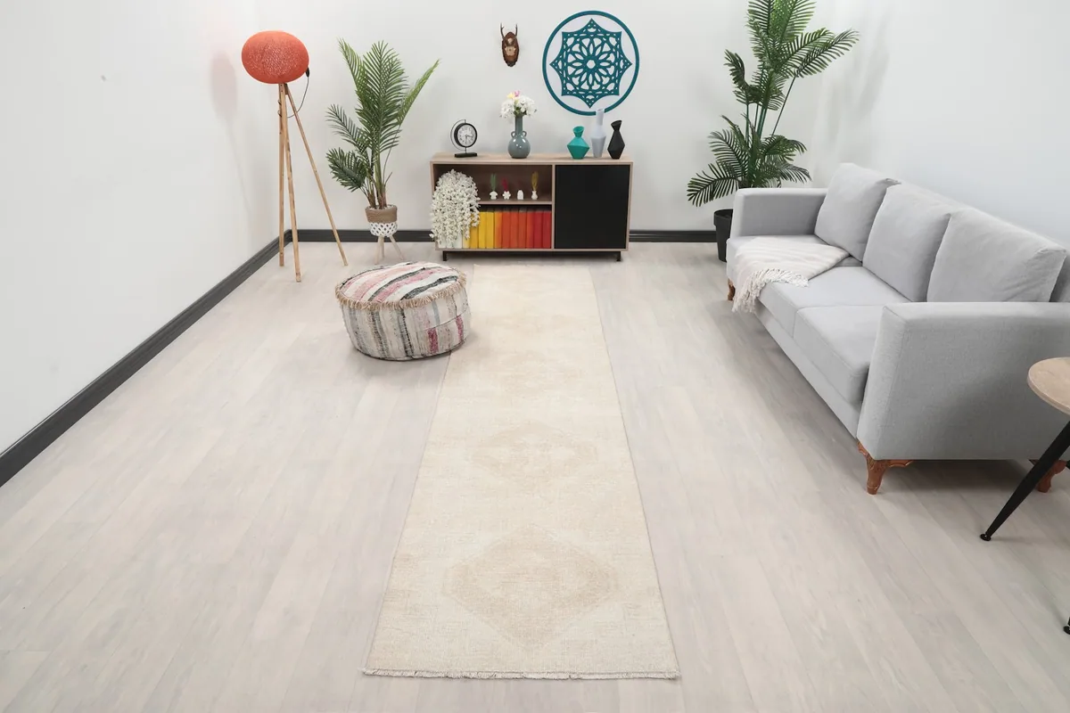 Runner rug displayed in a bright living room setting with a light-colored sofa and ottoman
