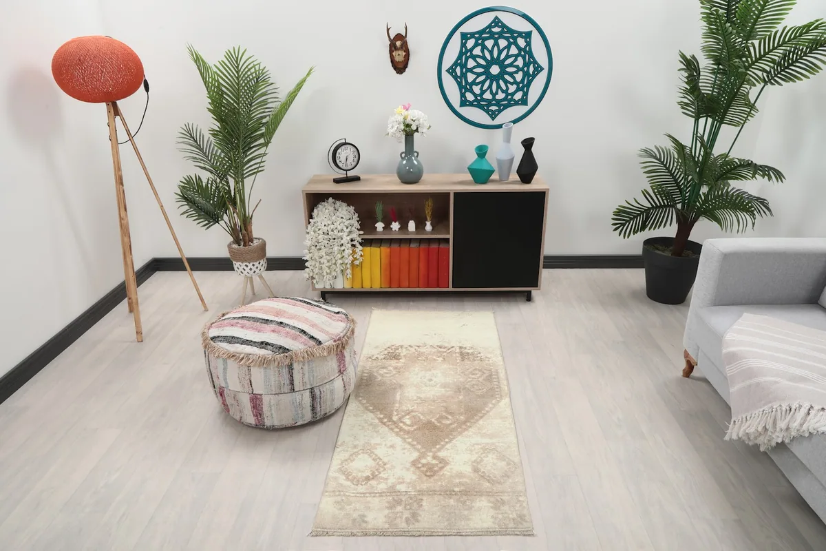 Vintage ivory and tan rug in a modern living room setting with plants and furniture