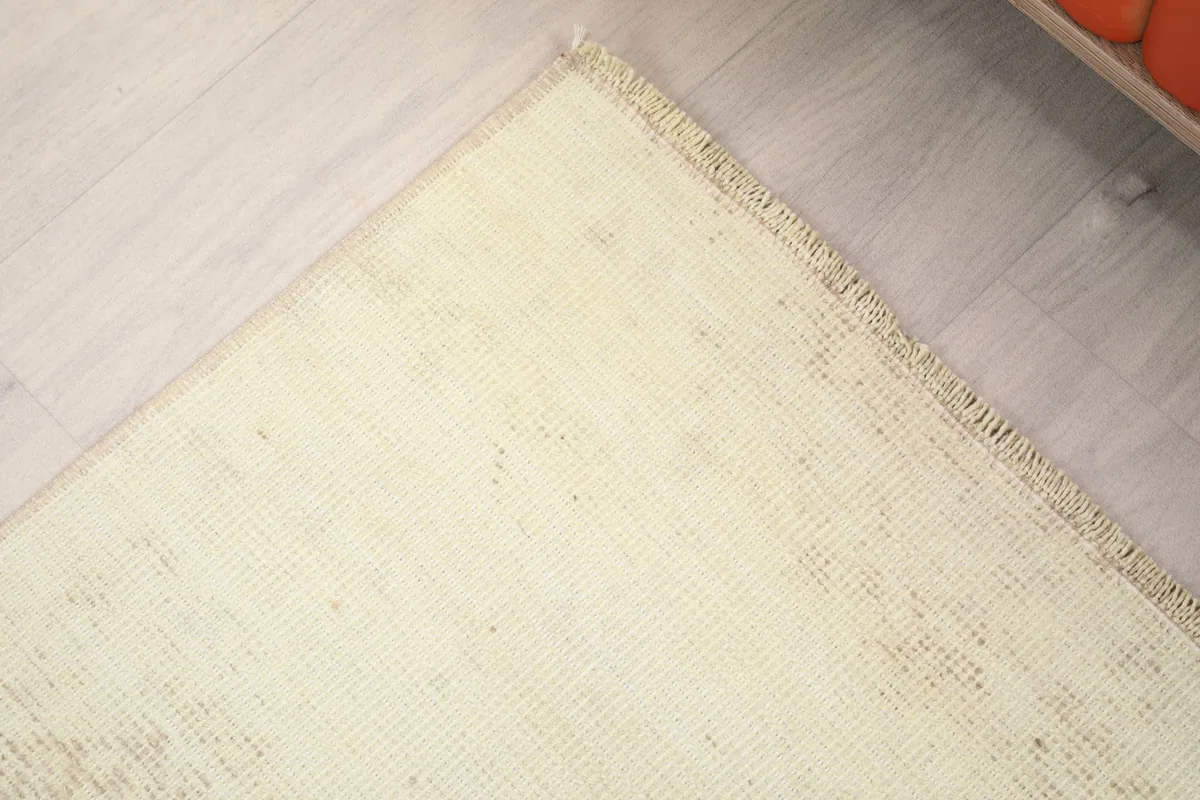 Detail of the rug's edge, showing the natural fringe and the tight weave