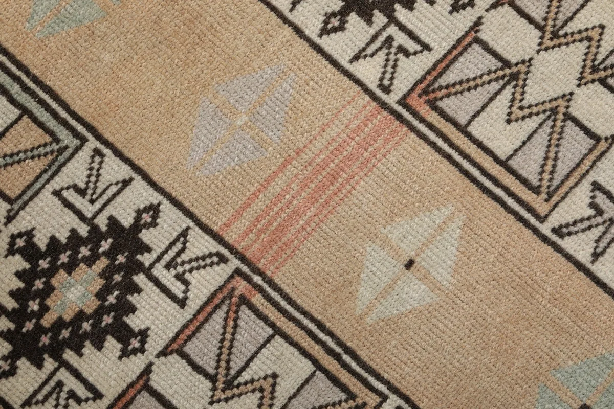 Close-up of the low wool pile texture and subtle color variations, highlighting its vintage character.
