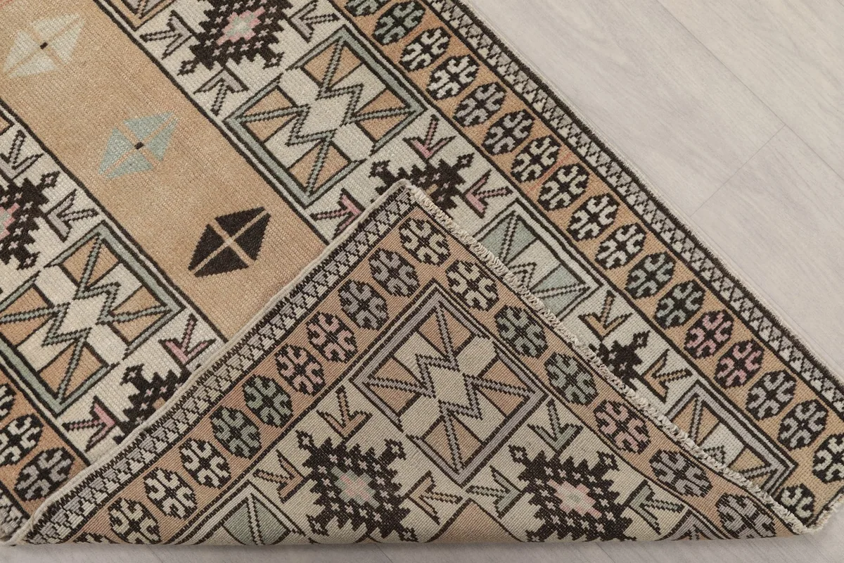 Corner of the rug folded to show the backside, revealing the hand-knotted cotton foundation.