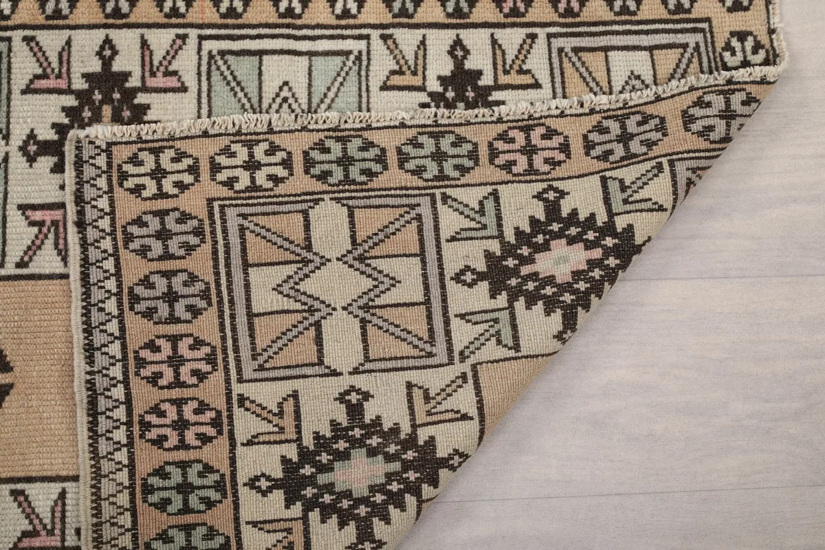 Close-up of the rug's edge and fringe, along with a glimpse of the hand-knotted structure.