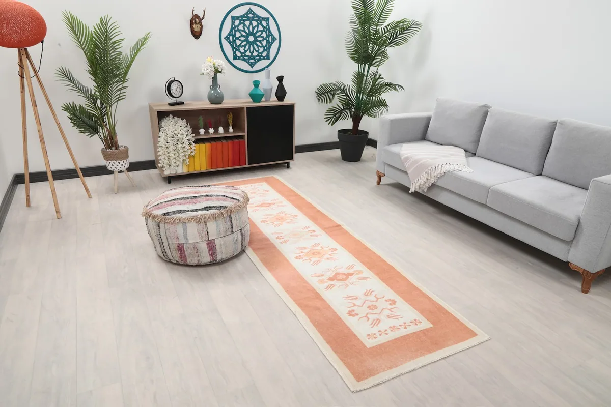 Angled view of the orange and ivory Anatolian runner rug in a modern living space.