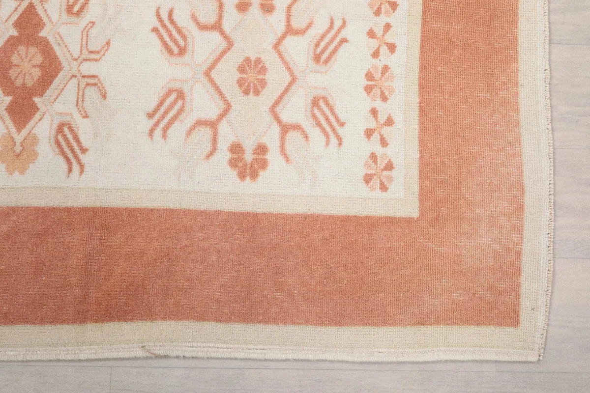 Detail of the orange border and ivory field with geometric motifs on the hand-knotted runner.