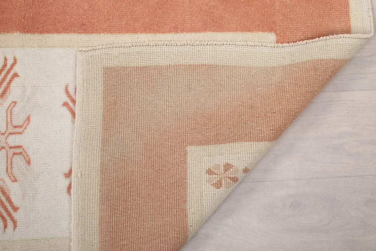 Underside of the hand-knotted wool rug, revealing the tight knotting on the cotton foundation.