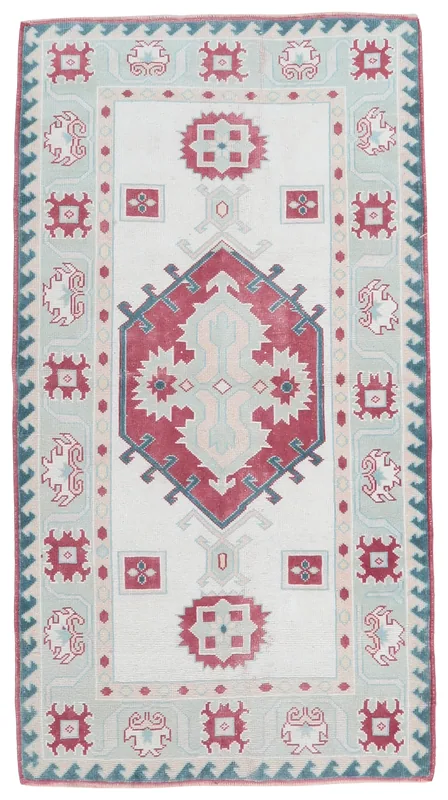 Full top view of the 3'11" x 6'4" ivory, red, and green vintage Anatolian rug