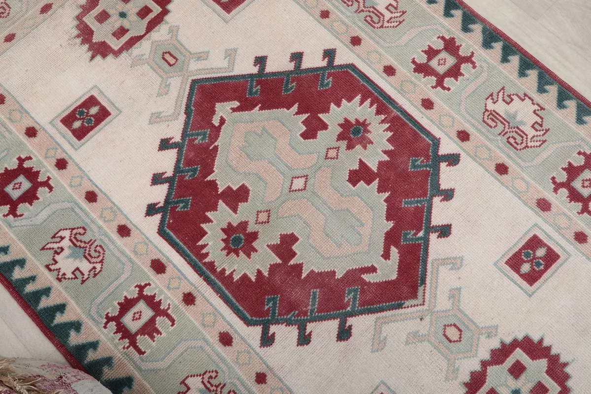 Angled view highlighting the red central medallion and surrounding ivory field