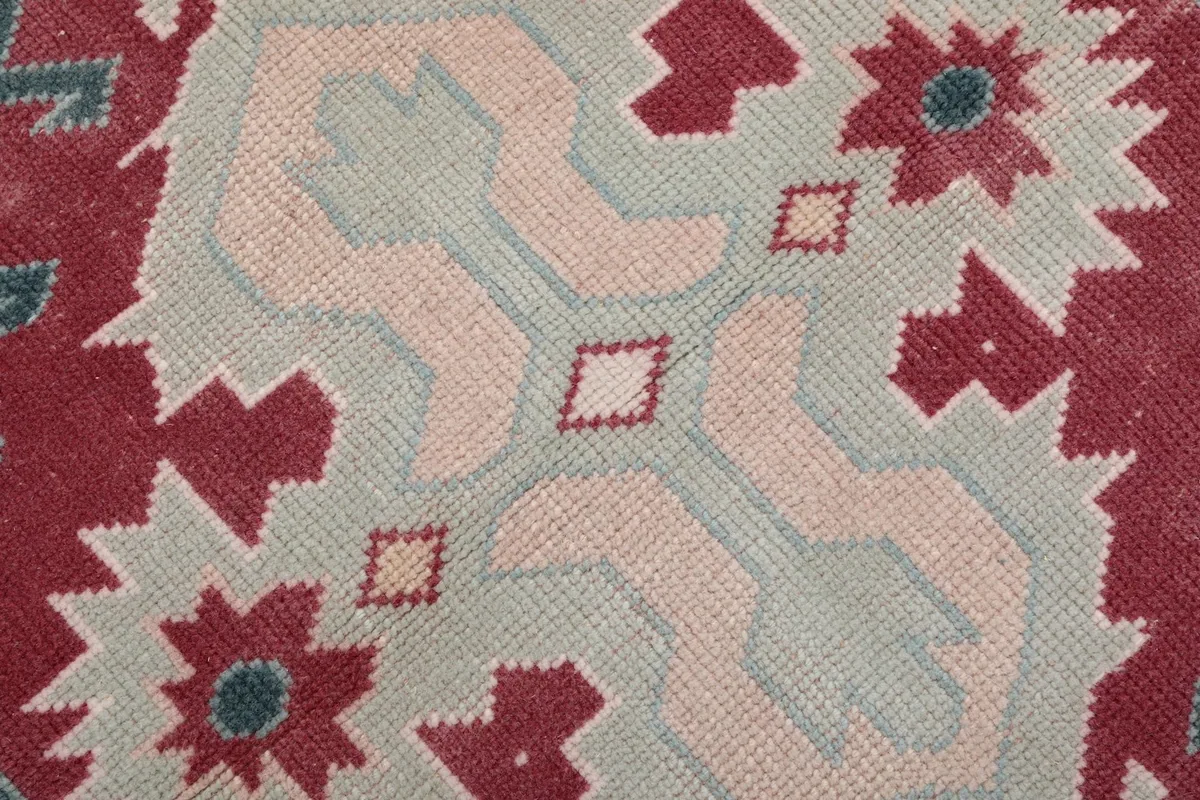 Macro detail of the hand-knotted wool pile, showing colors and texture of the central motif