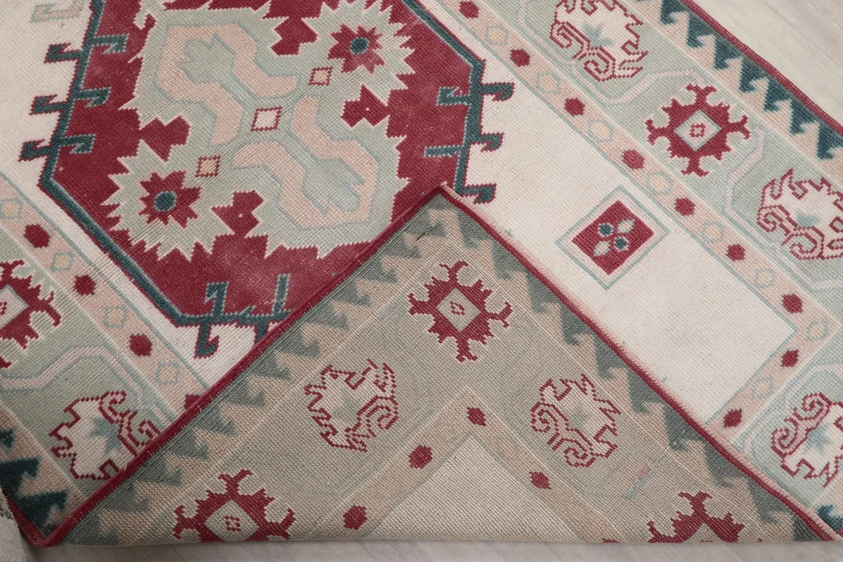 Folded corner of the rug revealing the cotton foundation and reverse side of the knots