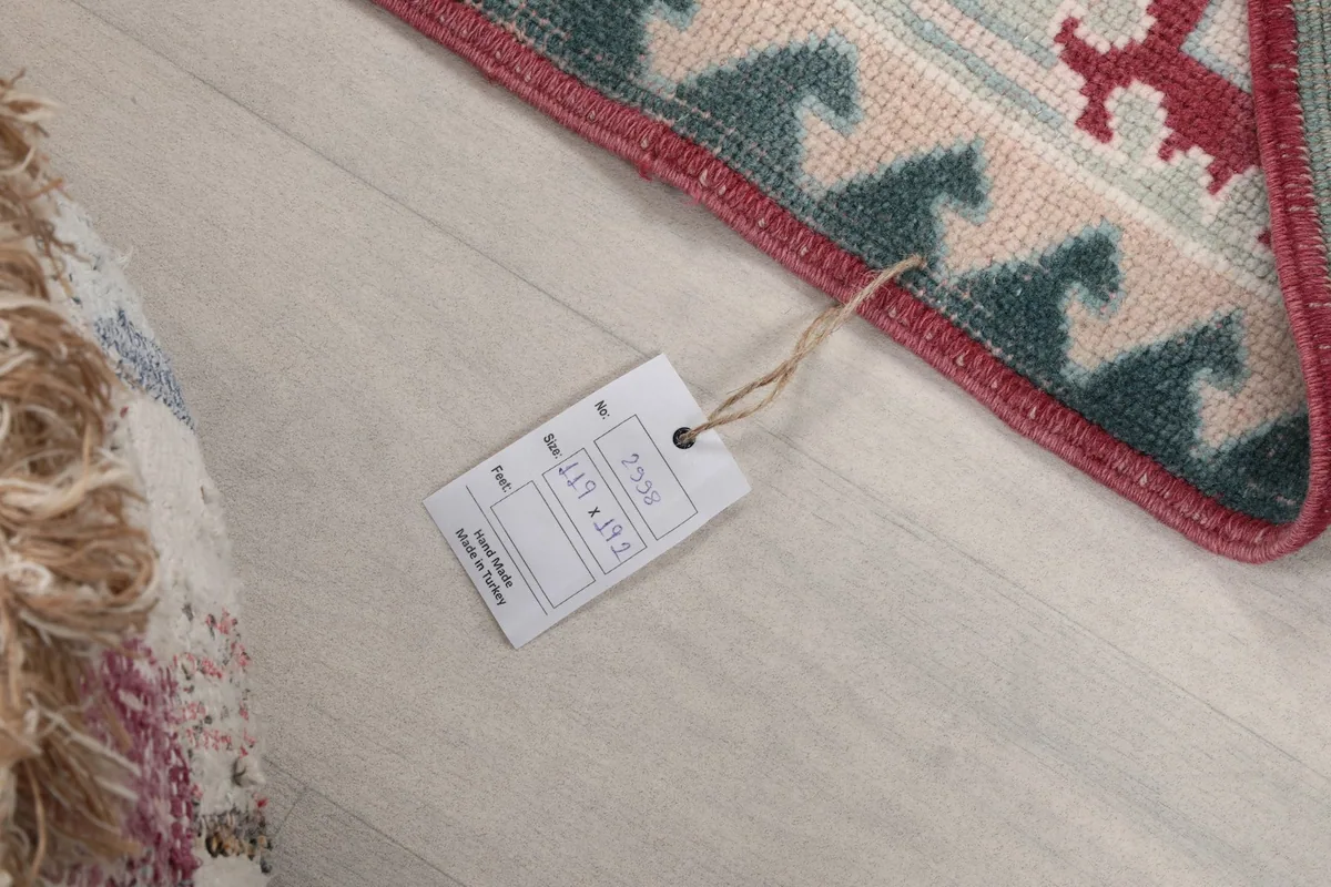 Detail of the rug's corner with the product tag, showing dimensions and origin