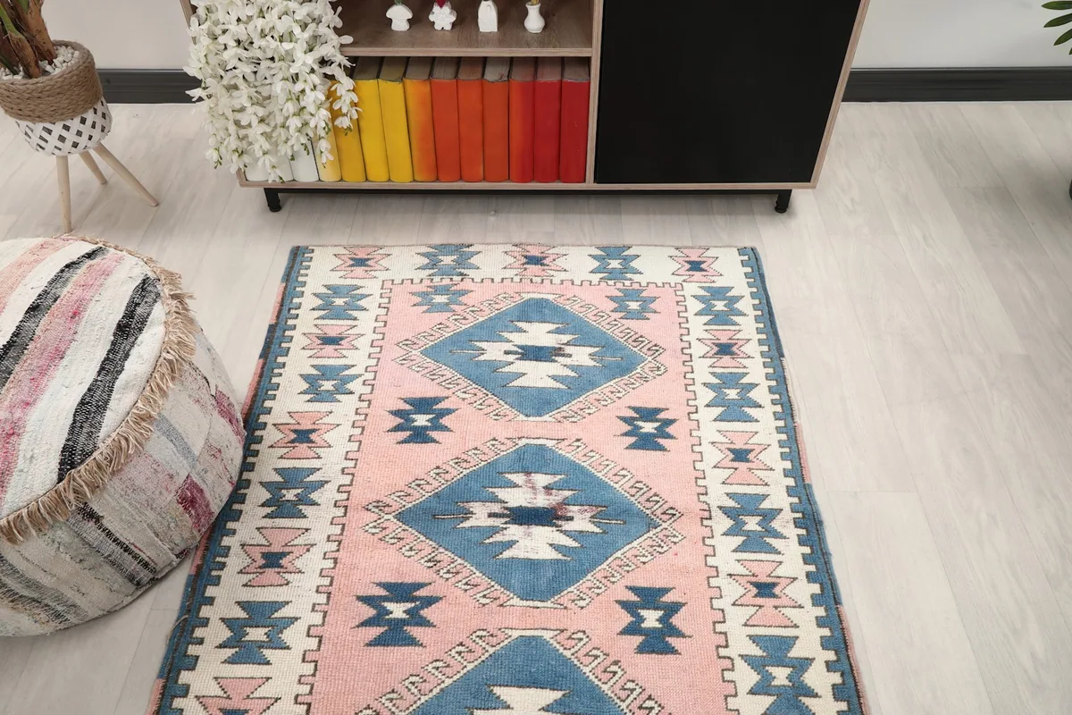 Full view of the pink and blue rug in a room setting, seen from a slightly elevated perspective.