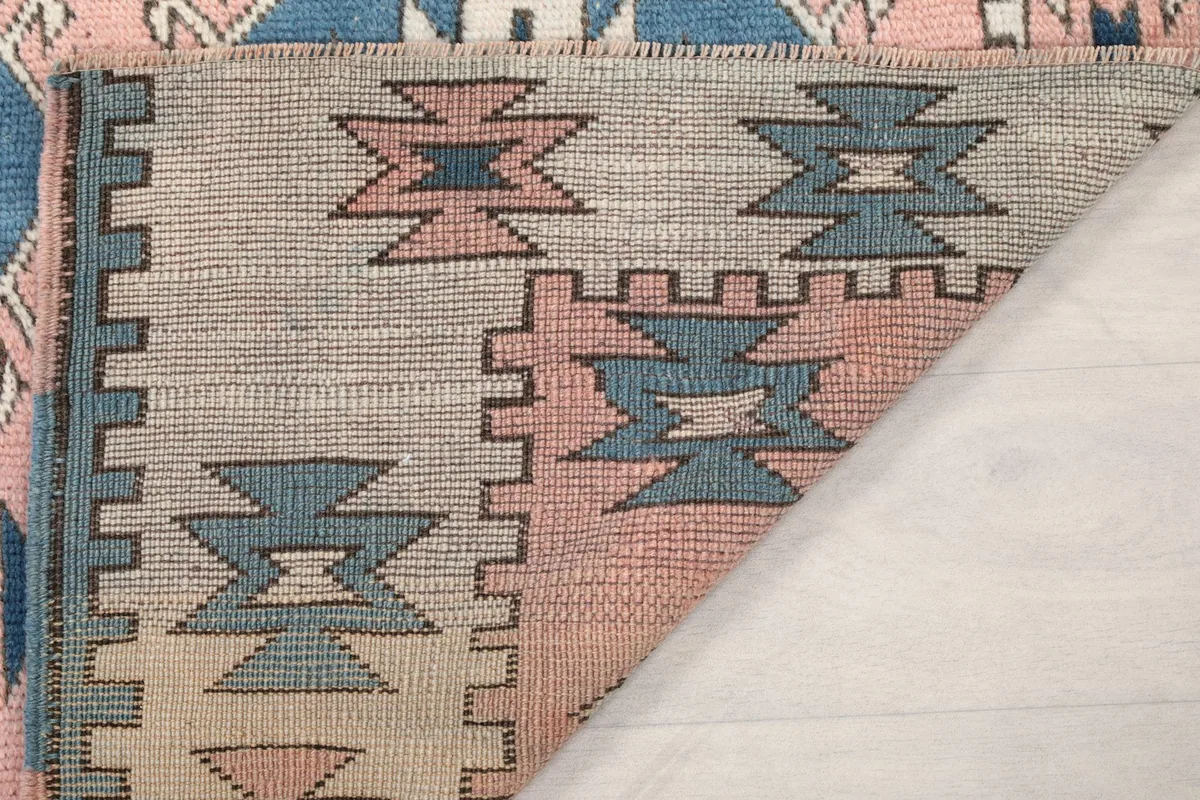 Another view of the back of the rug, revealing the woven cotton foundation and knotting.