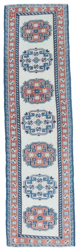 Full overhead view of the 2'4" x 9'7" vintage Anatolian runner rug with ivory, rust, and blue geometric patterns