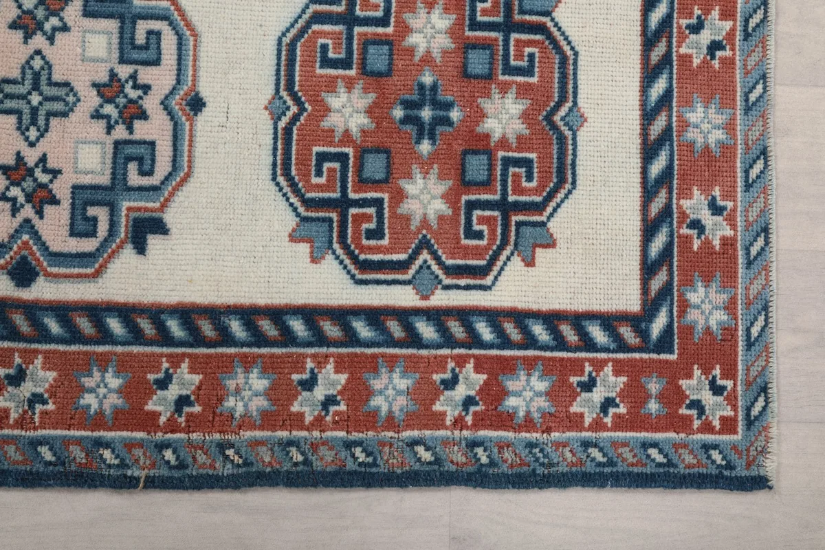 Detailed view of the rug's border and a rust-colored geometric medallion