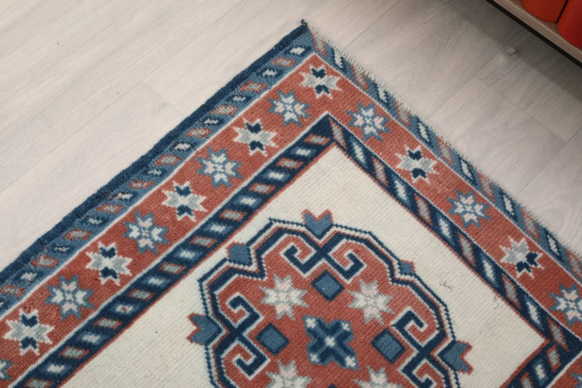 Corner detail of the rug, showing the intricate blue and rust borders