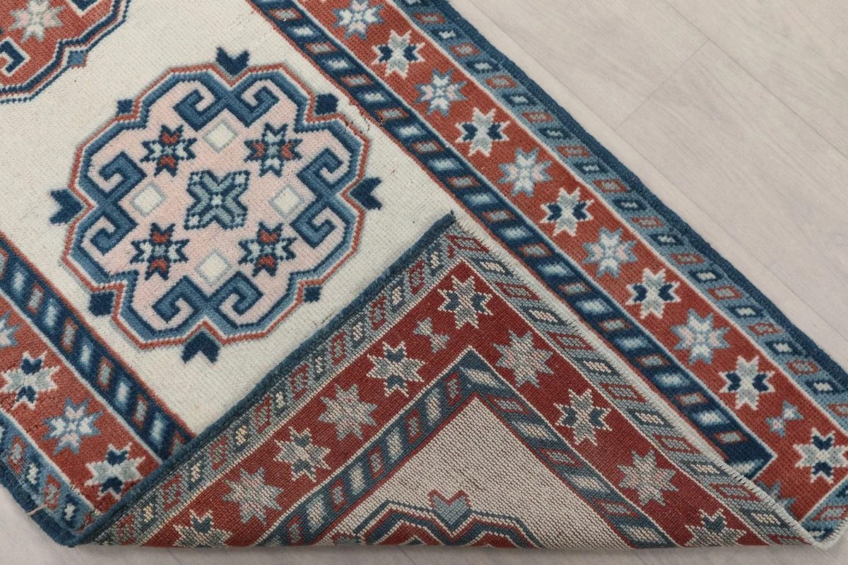 Folded corner of the rug, revealing the back of the hand-knotted wool and cotton foundation