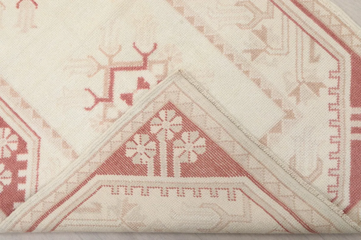 Folded corner of the rug, revealing the back of the weave and pile depth