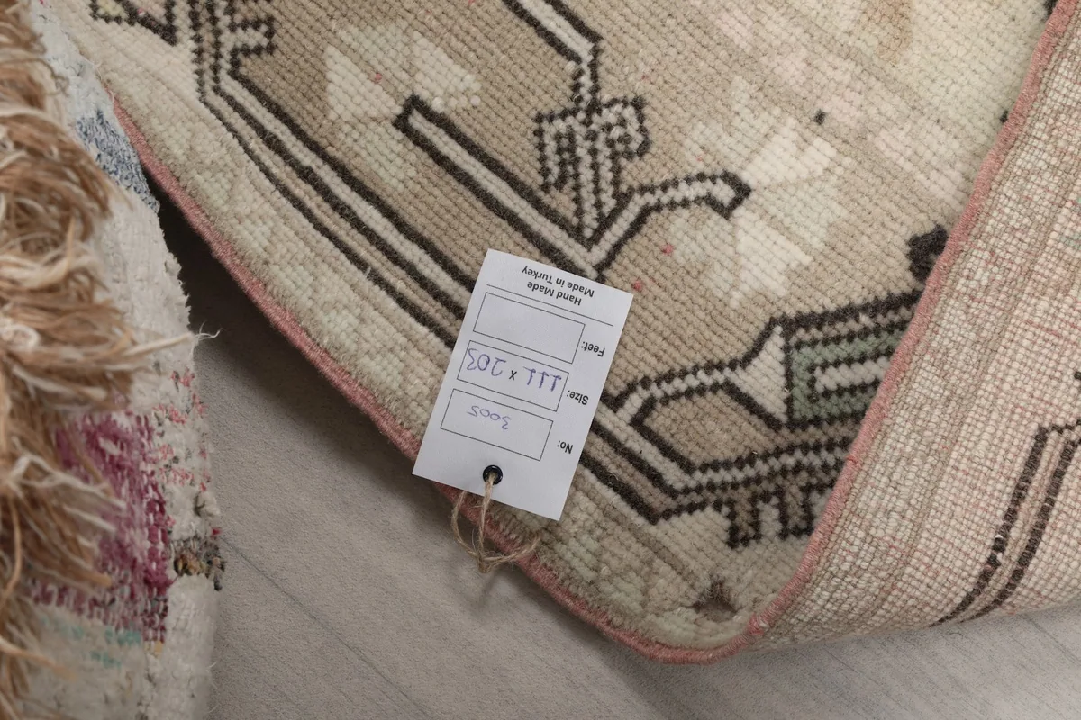 Close-up of the rug's back with a tag, confirming the hand-knotted wool on cotton construction.