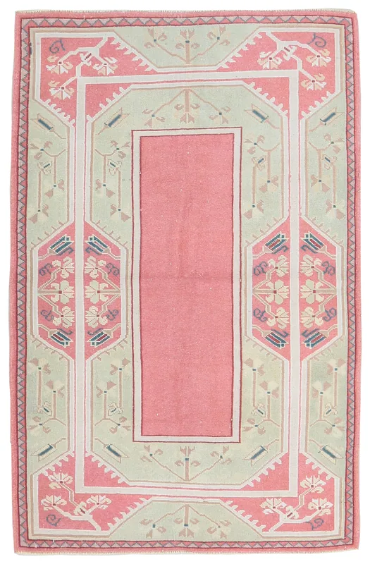 Full top view of the vintage pink and green Anatolian hand-knotted wool rug.