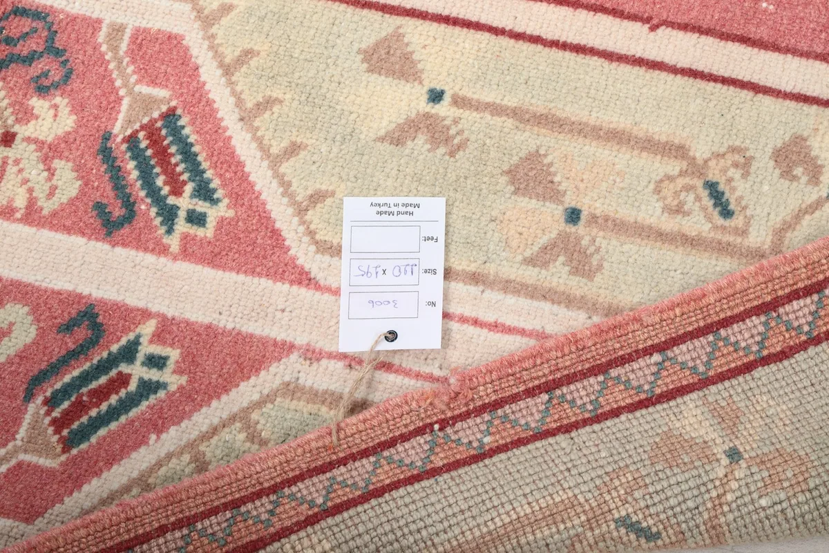 View of the back of the rug with a label, showing the tight hand-knotted construction.