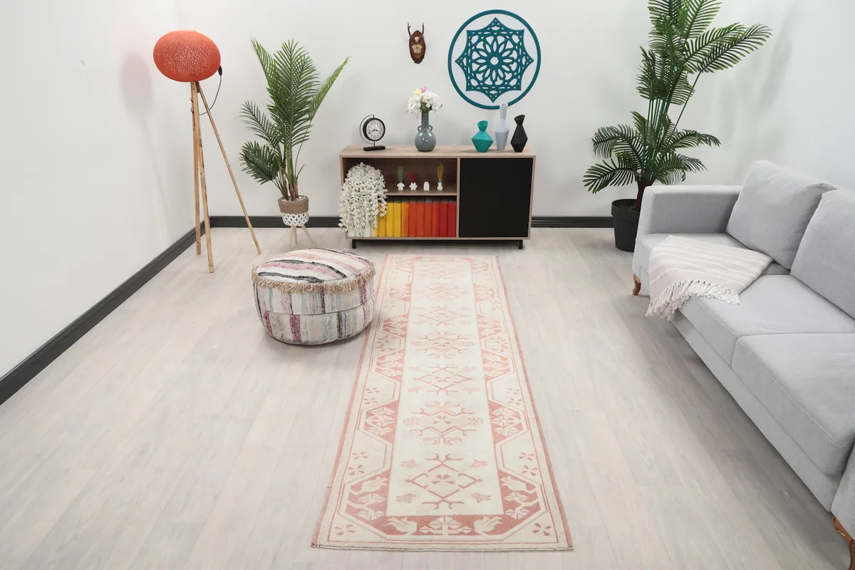 Rose and ivory runner rug in a living room setting, showing its long shape