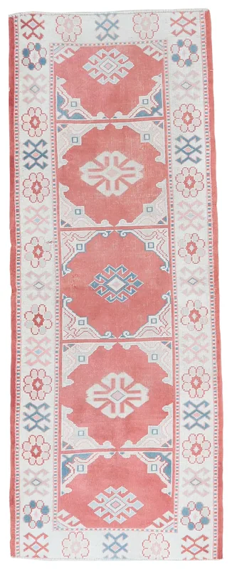Full top view of the 2'7" x 7'3" rose and ivory geometric Anatolian runner on a white background.