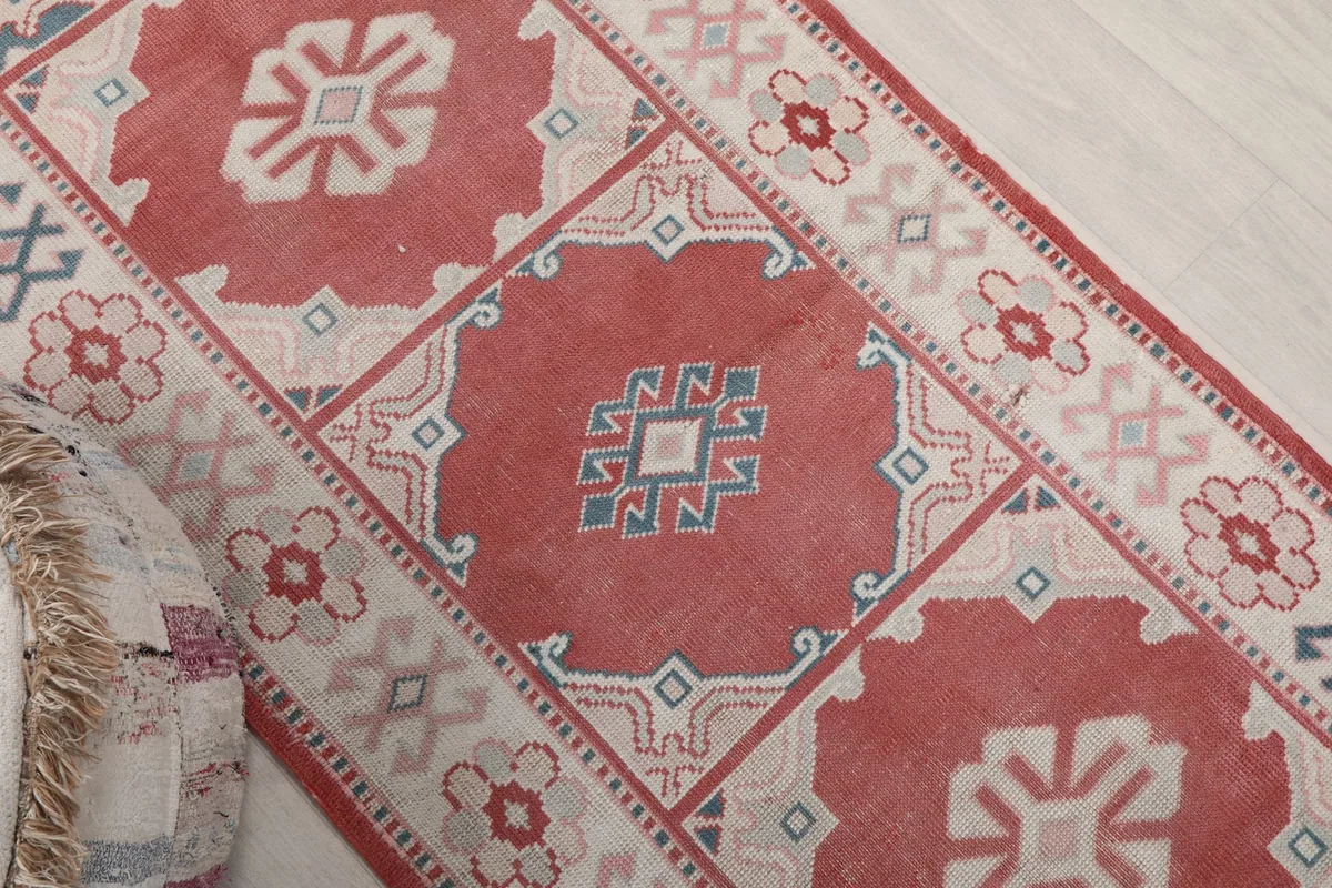 Overhead close-up of the rug's center, highlighting a rose medallion with blue and ivory geometric patterns.