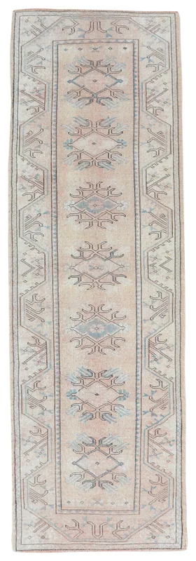 Full top view of the vintage rose beige tribal Anatolian runner on a white background