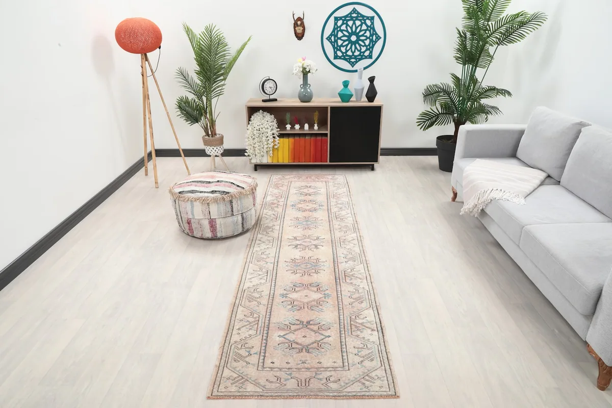 Vintage beige runner rug in a living room setting with a sofa and plants