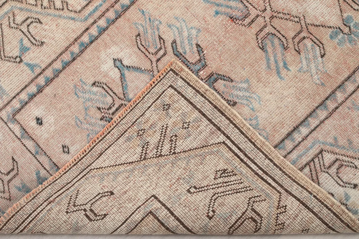 Corner of the rug folded to show the hand-knotted back and foundation