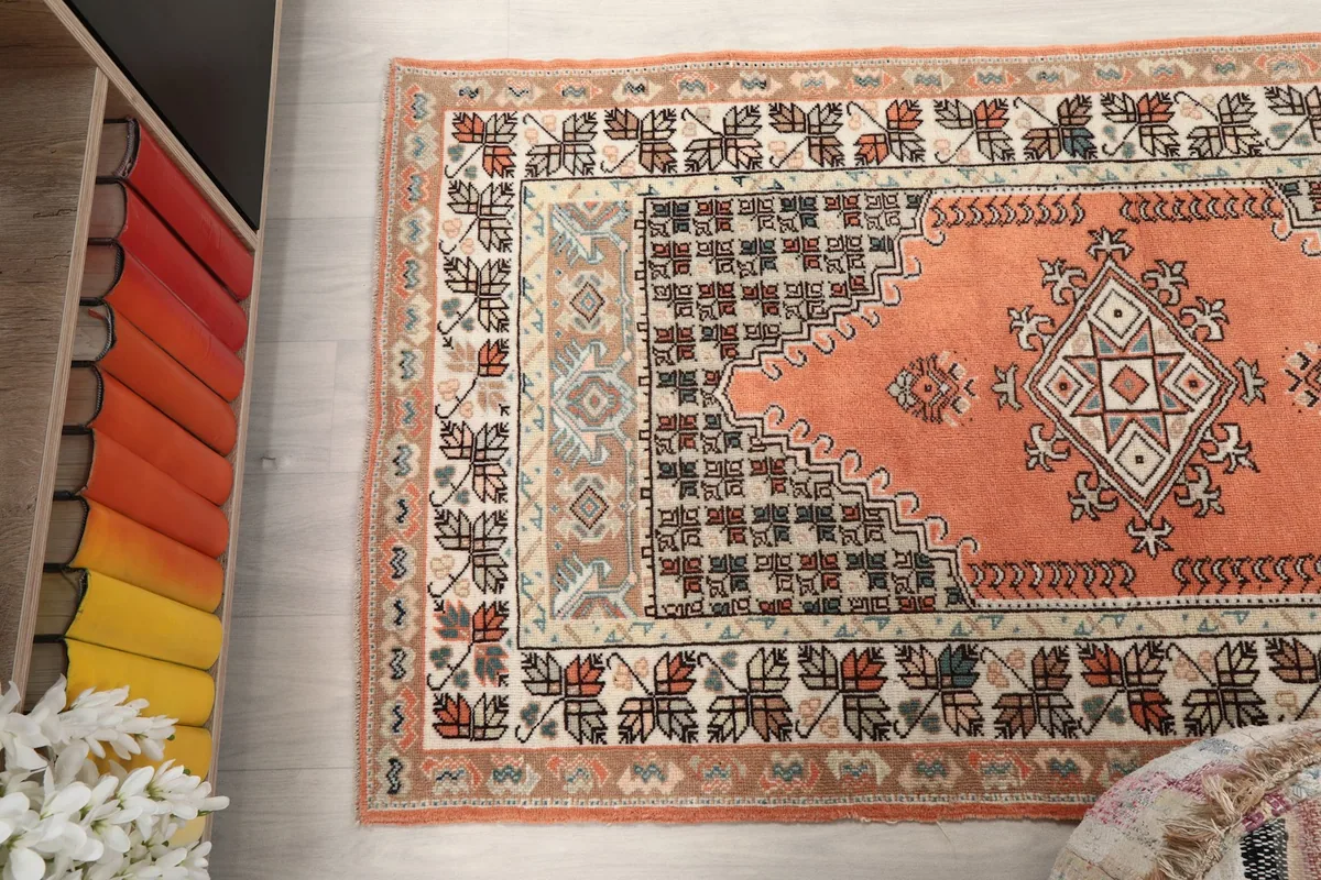 Side angle of the orange rug, emphasizing the blend of colors and patterns