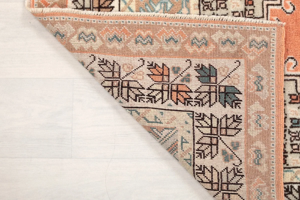 Underside view of the rug's corner, showing the hand-knotted construction