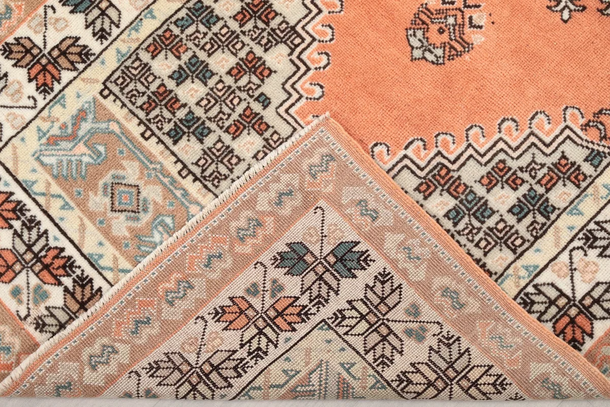 Folded corner of the rug, revealing the wool pile and cotton foundation