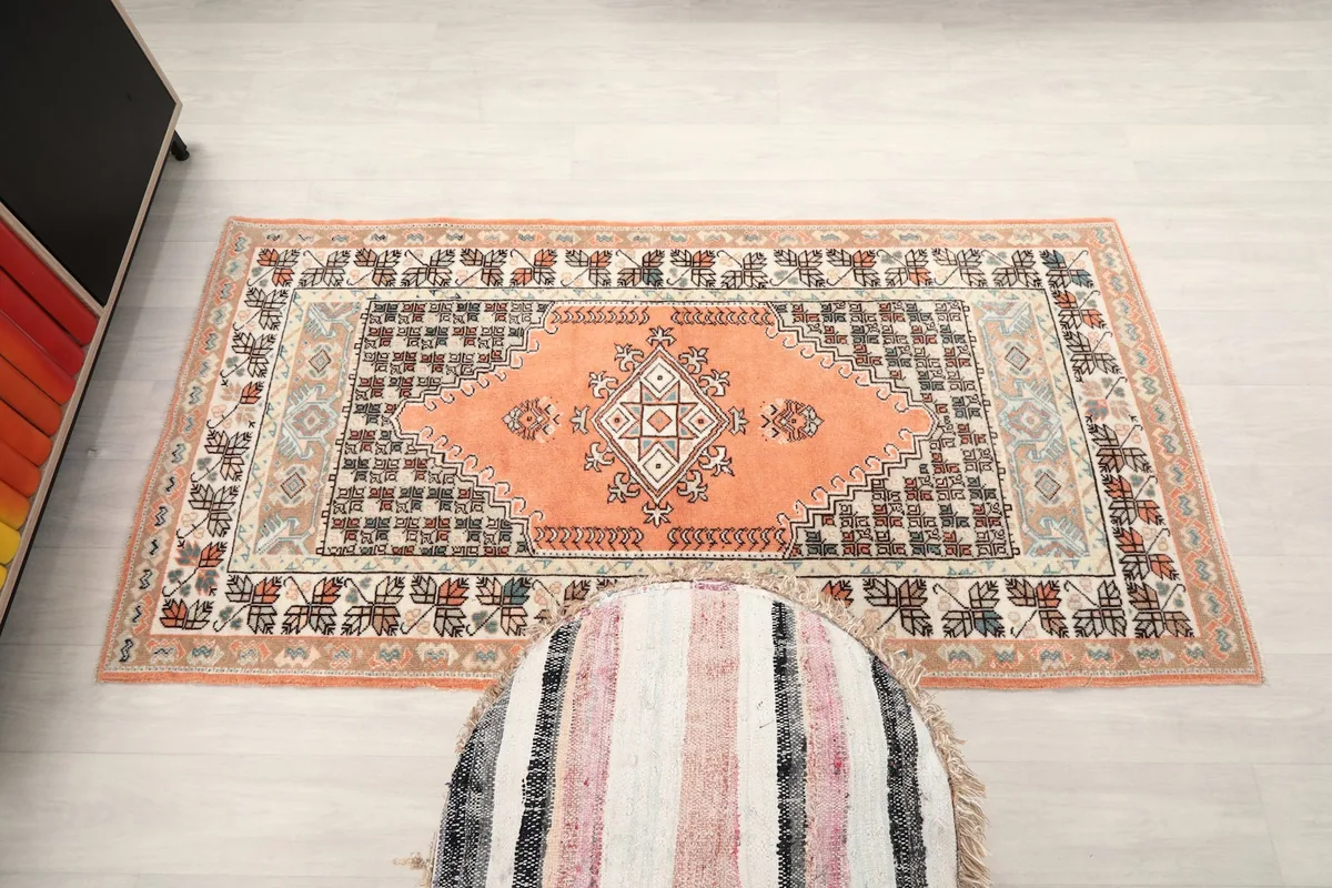 Full overhead view of the orange vintage rug, showing its rectangular shape and design