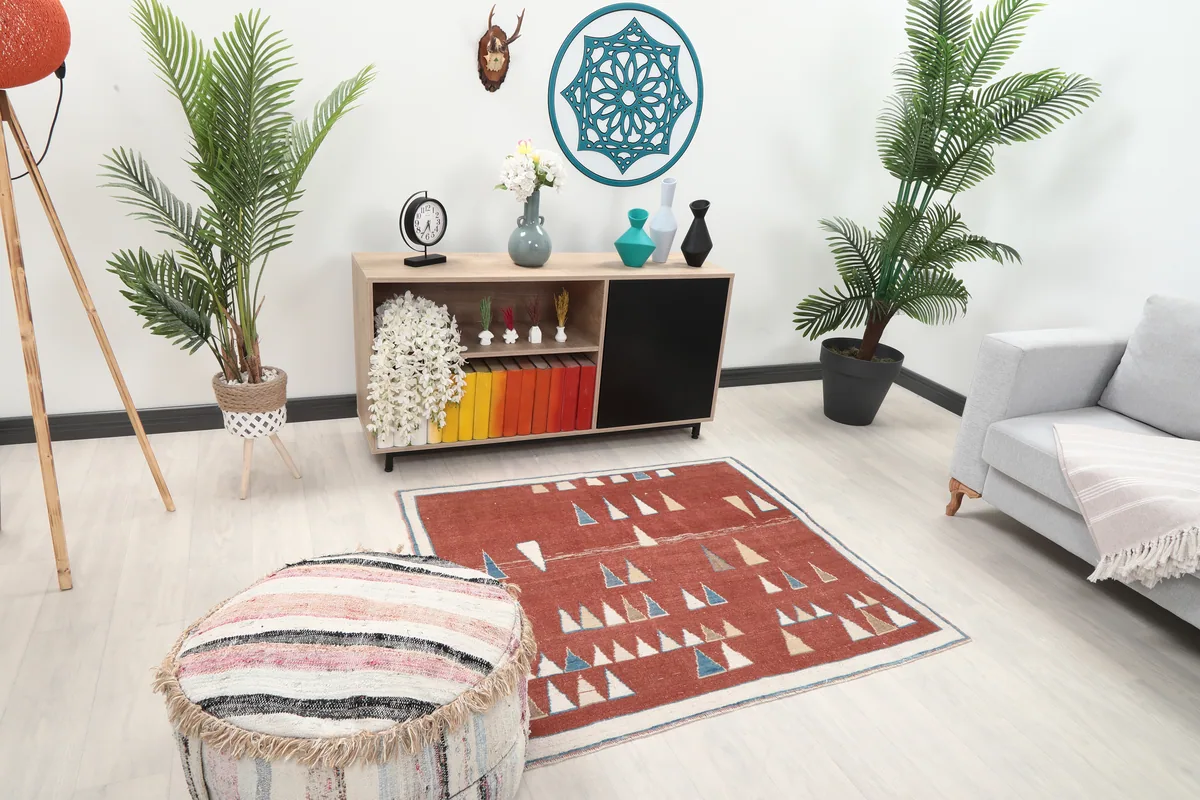 Rust Geometric Anatolian Rug in a room setting, showing its size relative to a sofa and cabinet.