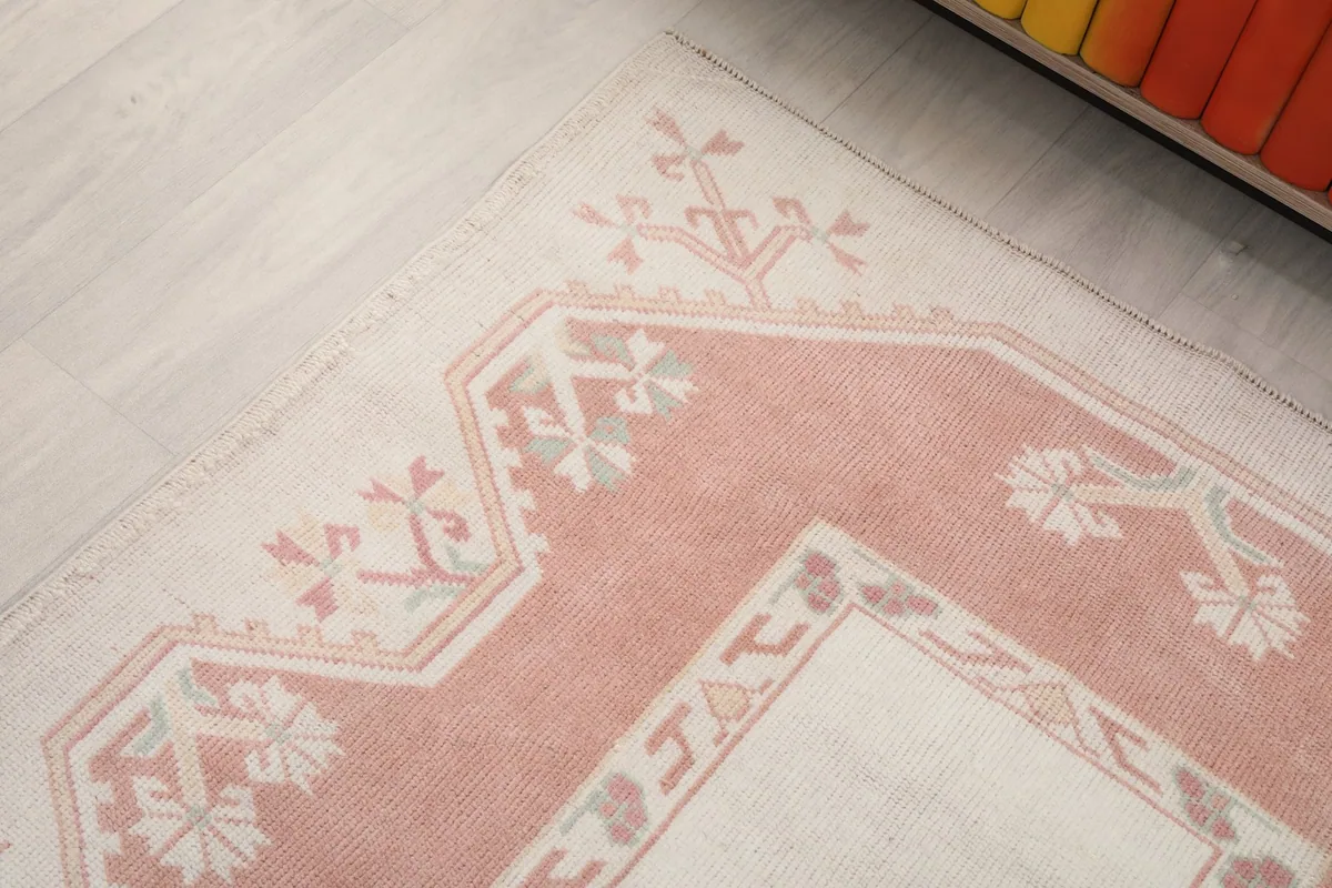 Detailed view of the upper corner of the rug, showing the intricate geometric and floral-like motifs.
