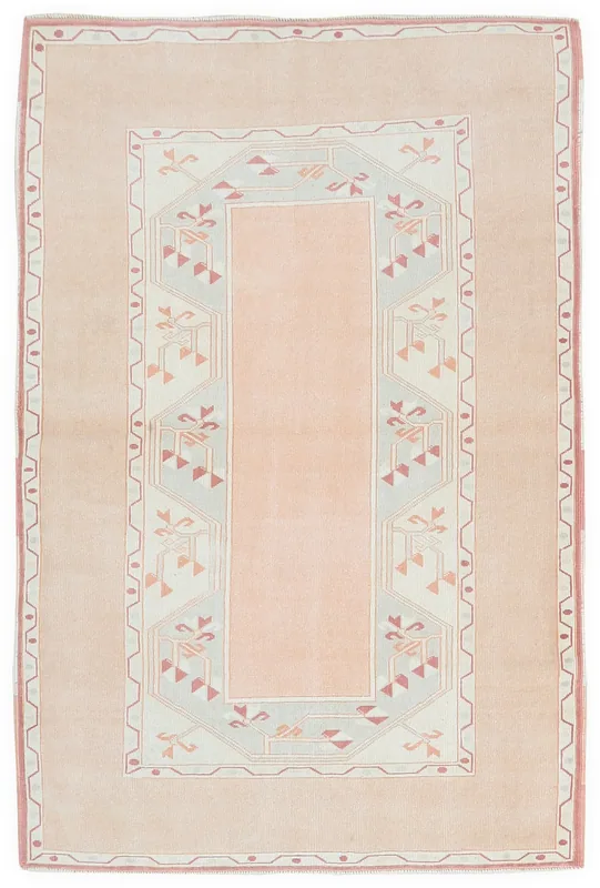 Full overhead view of the vintage pink and beige Anatolian rug on a white background
