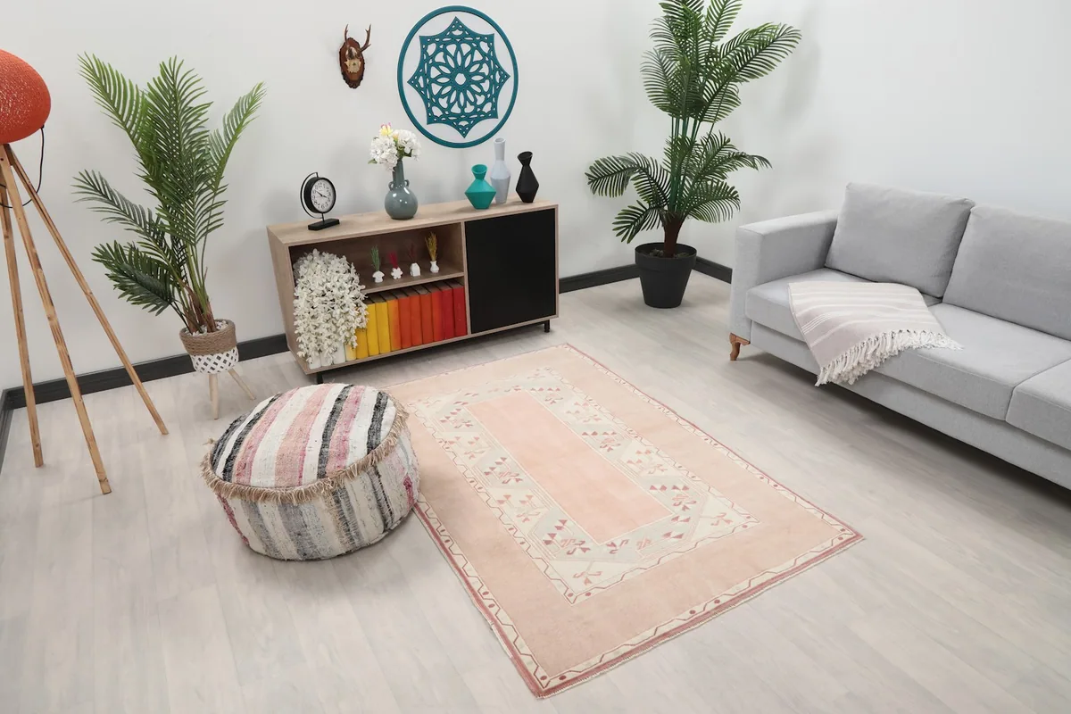 Angled view of the pink and beige geometric rug in a modern living space