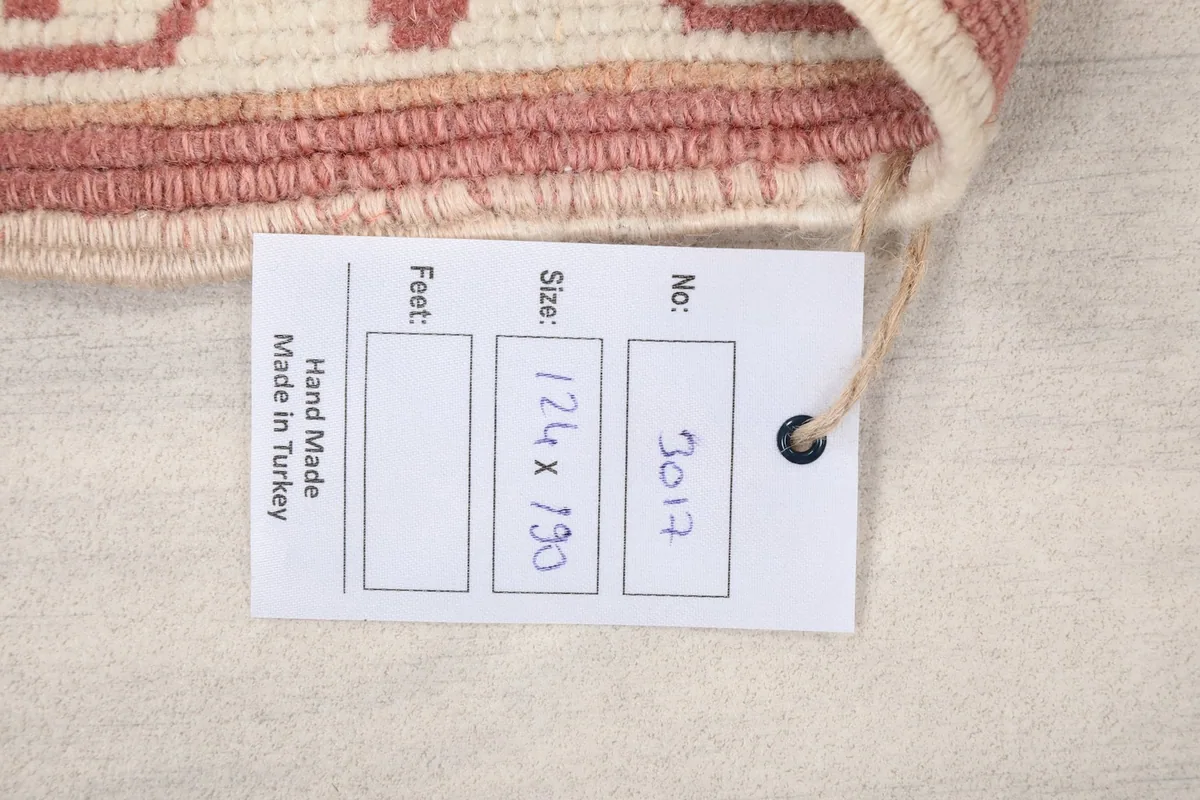 Tag showing the rug's measurements in centimeters and its handmade origin from Turkey