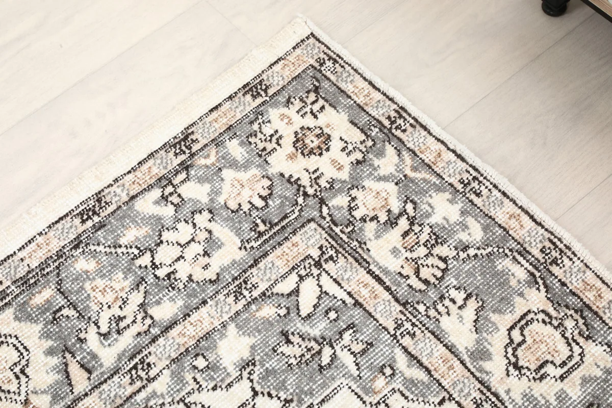 Corner detail of the rug, showing the border design and color variations