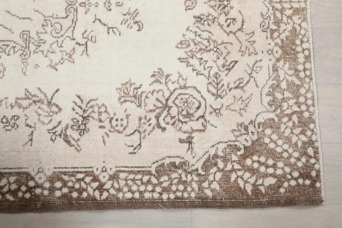 Close-up of the brown floral border design on the ivory field