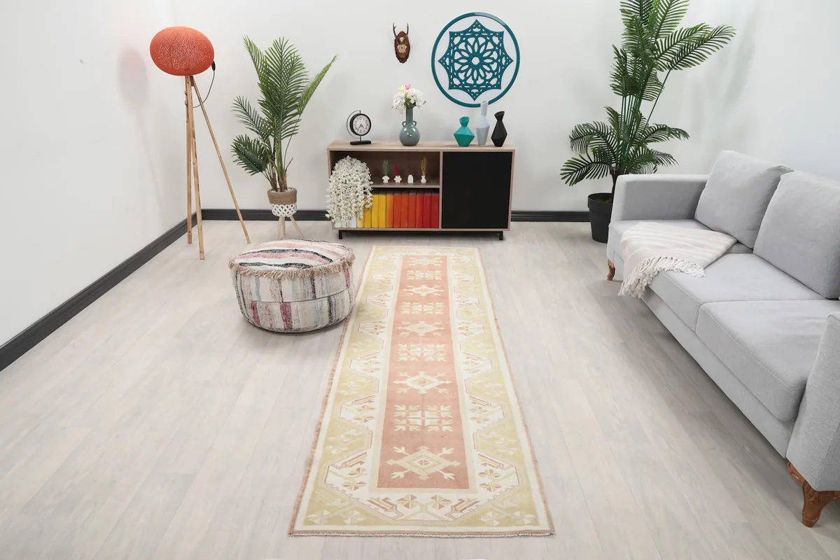 Runner rug displayed in a living room setting with a light-colored sofa and wooden floor.