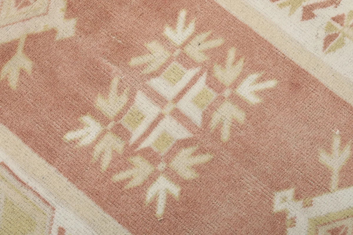Macro detail of a single geometric motif in the rose field, showing color variations and texture.