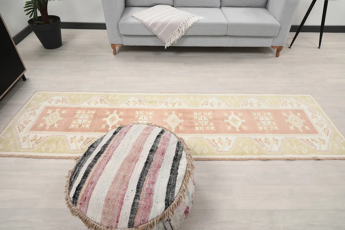 Overhead view of the entire runner rug in a room with a sofa and pouf, illustrating its scale.
