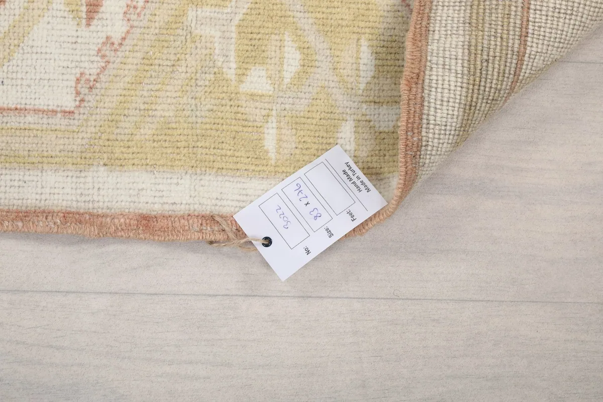 Corner of the rug with a product tag displaying size and origin details.