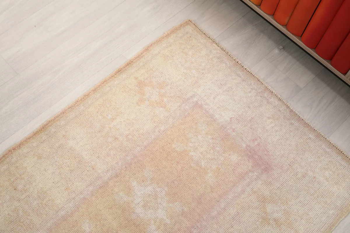 Corner of the runner rug showing its texture and faded colors